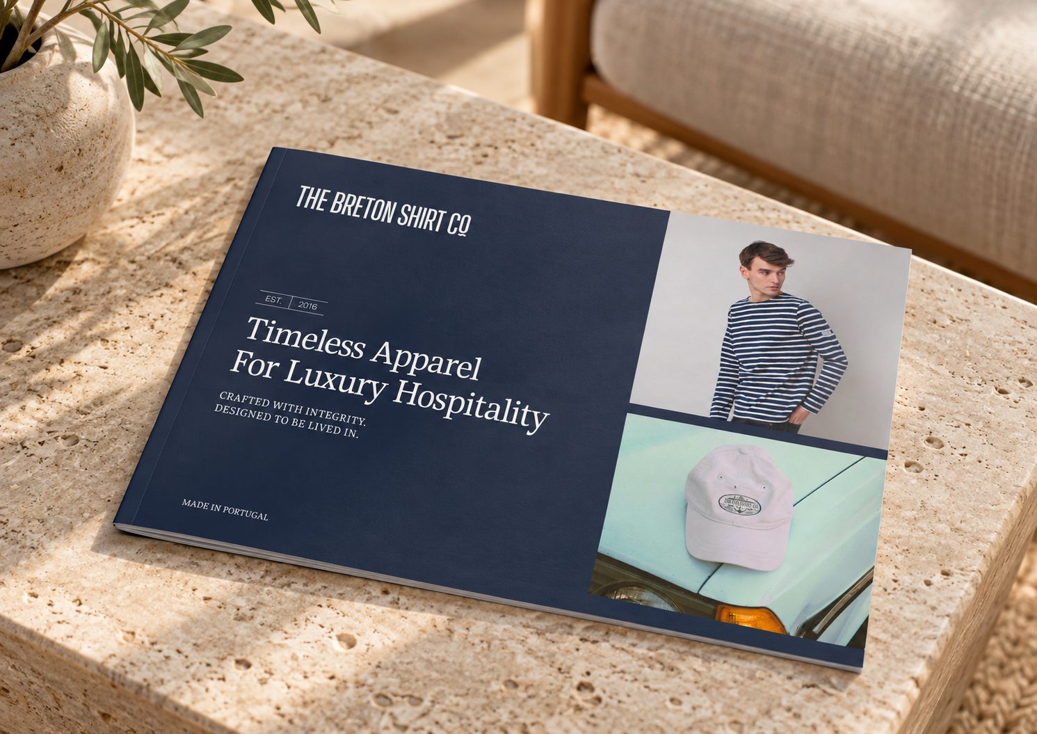 Navy Breton Shirt Co brochure cover on a travertine table